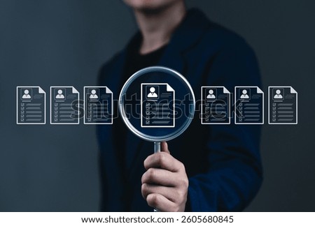 Resume Screening and Candidate Evaluation Concept. A person holds magnifying glass focusing on digital resume among several profiles, symbolizing resume screening and recruitment selection processes.