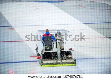 Resurfacing machine cleans ice of hockey rink