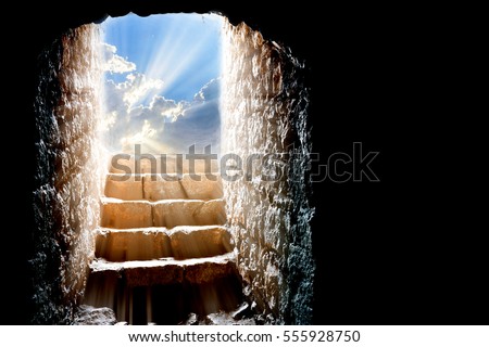 Resurrection of Jesus Christ. Religious Easter background, with strong light rays shining through the entrance into the empty stone tomb. Artistic strong vignette, contrast, dramatic dark-light edit.