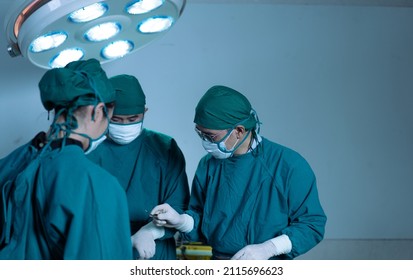 Resuscitation Medical Team Perform Surgical Operation In Operating Room. Group Of Surgeon Serious Working To Saving Patient Life At Hospital Theatre. Copy Space