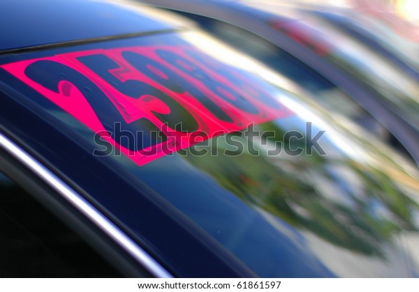 Retail Business Image of Price\
Stickers on a Row of Used Cars, With Shallow Depth of\
Focus