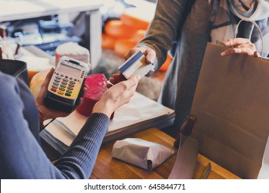 Retail, credit card payment service. Customer paying for order of cheese in grocery shop. - Shutterstock ID 645844771