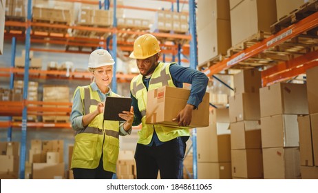 Retail Warehouse Full Of Shelves With Goods In Cardboard Boxes, Male And Female Supervisors Use Digital Tablet Discuss Product Delivery. Forklift Working In Logistics Storehouse