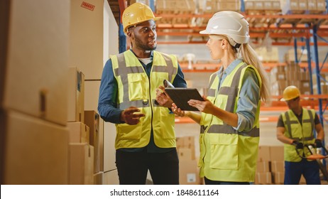 Retail Warehouse full of Shelves with Goods in Cardboard Boxes, Male Worker and Female Supervisor Holding Digital Tablet Discuss Product Delivery while Scanning Packages. Distribution Logistics Center - Powered by Shutterstock