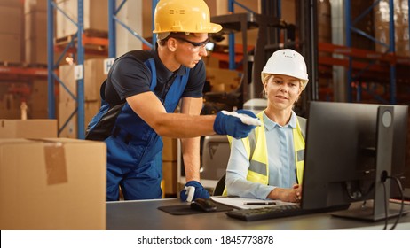 In Retail Warehouse Manager Uses Computer With Inventory Checking Software, Talks With Storehouse Worker About Package Delivery. International Distribution Center With Shelves Full Of Products