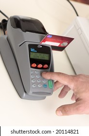 A retailer, salesman or customer using an eft pos machine to make a transaction payment.  Focus to hand and machine only.