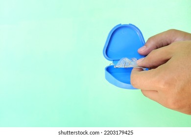 Retainer care and safekeeping concept. Hand putting hawley dental retainers in a protective case with copy space. - Shutterstock ID 2203179425