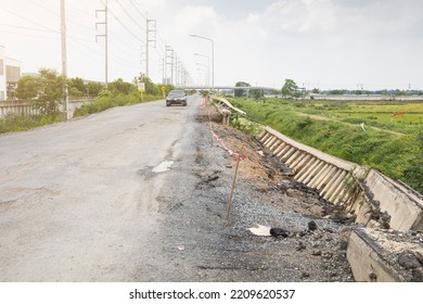 Retaining Wall Collapse And Crack Alongside Of The Road With Car In The Background