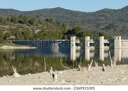 Retaining wall of the Beniarrés reservoir with the gates open and low water level in the lake due to climate change, Spain