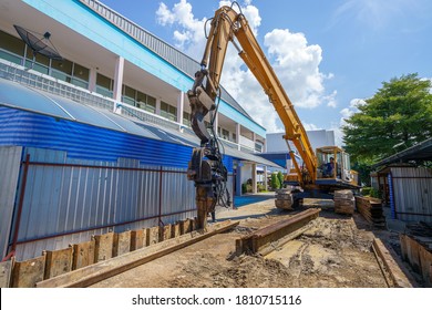 Retaining wall steel sheet pile driving by vibro diesel hammer machine working under the construction site