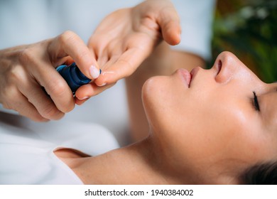 Retinol Treatment. Cosmetician Applying Retinol Serum On Woman’s Face