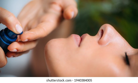 Retinol Treatment. Cosmetician Applying Retinol Serum On Woman’s Face