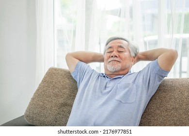 A retired Asian senior man , old man smiling , senior man relaxing on the sofa in the living room at his home - lifestyle senior happiness concept - Powered by Shutterstock