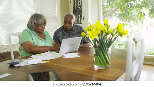 Retired black couple paying bills on the computer