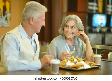 Retired Couple Eating French Fries In Cafe