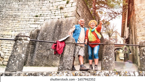 Retired Couple Having Genuine Fun In San Marino Old Town Castle - Active Travel Lifestyle Concept With Mature Seniors At Italian Roadtrip - Warm Bright Filter With Selective Focus On People