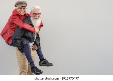 Retired Couple Playing To Be Young. Elderly Couple Having Fun. Best Elderly Friends Laughing At The Camera. Retired And Young Concept.