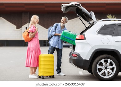 A retired couple prepares for a road trip by packing their luggage into the trunk of their car, emphasizing the freedom and joy of elderly life together - Powered by Shutterstock