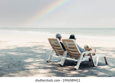 Retired Couple Resting Happily On A Adirondack Chair By The Beach. Retirement Planning Ideas And Happy Life.