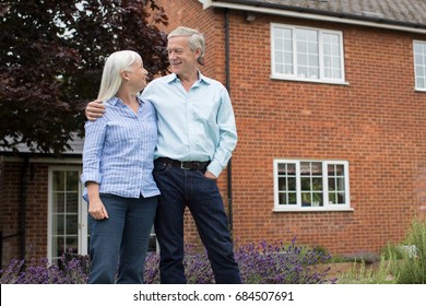 Retired Couple Standing Outside Home