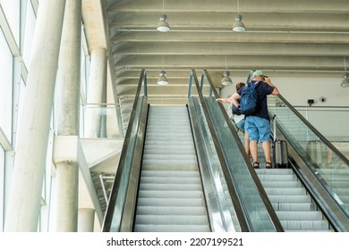 Retired couple with suitcases go up the escalator of a transport station. - Powered by Shutterstock