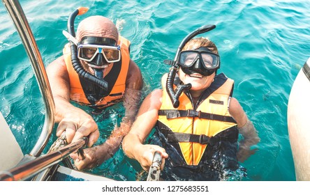 Retired Couple Taking Happy Selfie In Tropical Sea Excursion With Life Vests And Snorkel Masks - Boat Trip Snorkeling In Exotic Scenarios On Active Elderly And Senior Travel Concept Around World