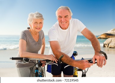 Retired couple with their bikes on the beach - Powered by Shutterstock