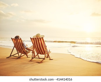 Retired Couple Watching Sunset In Vintage Beach Chairs  