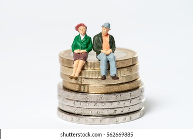 Retired / elderly couple sitting on euro coins