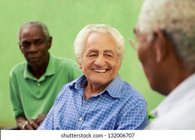 Retired Elderly People And Free Time, Group Of Happy Senior African American And Caucasian Male Friends Talking And Sitting On Bench In Park