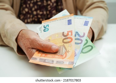 Retired Elderly Woman Holding Euro Banknotes Money And Worry About Monthly Expenses And Treatment Fee Payment.