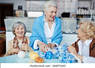 Retired females spending leisure together by knitting - Powered by Shutterstock