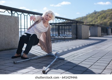 Retired Lady Getting Up From The Ground Outdoors