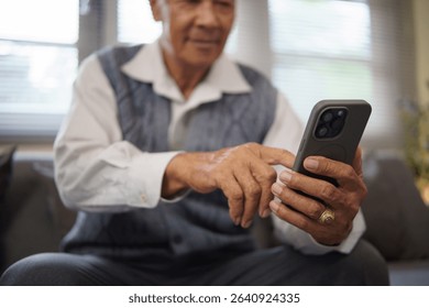 Retired man using mobile technology for staying connected or entertainment.