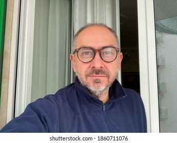 Retired Middle Aged Italian Man With Short Hair And Eyeglasses With Short Gray Beard And Blue Fleece