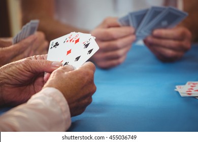 Пенсионеры играют в карты в доме престарелых