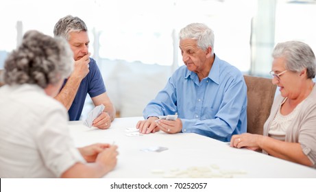 Retired People Playing Cards Together At Home