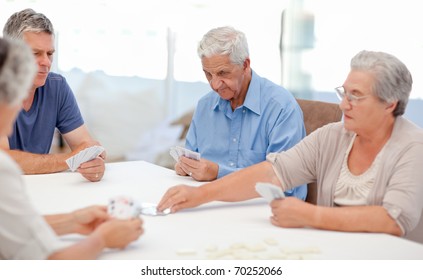 Retired People Playing Cards Together At Home