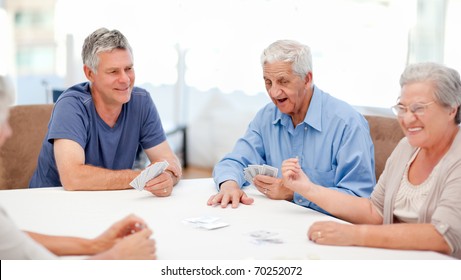 Retired People Playing Cards Together At Home