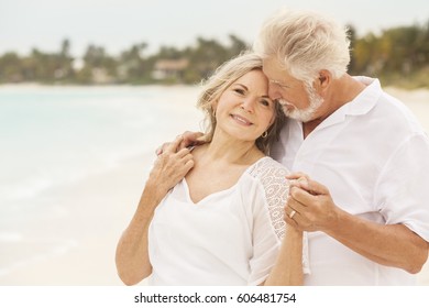 Retired senior Caucasian couple wearing white casual clothes together on peaceful summer travel resort beach