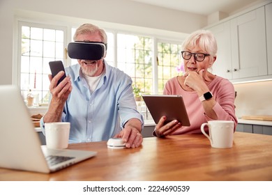 Retired Senior Couple In At Home Using Digital Tablet VR Headset Smartwatch Mobile Phone And Laptop - Powered by Shutterstock