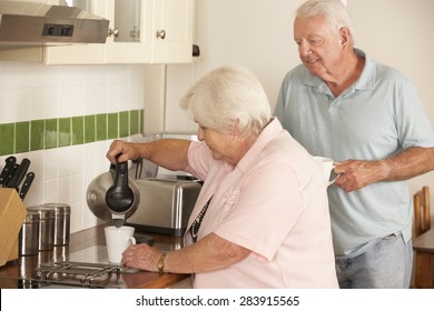 Retired Senior Couple In Kitchen Making Hot Drink Together - Powered by Shutterstock