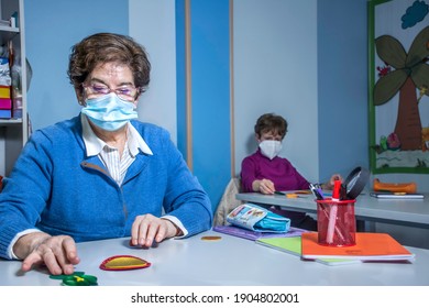 Retired Senior Woman Attending Class In Community Center, Wearing Face Mask, Social Distancing.  Keeping Social Distance In Classroom. Memory Exercises.