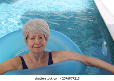 Retired senior woman with inflatable ring in swimming pool