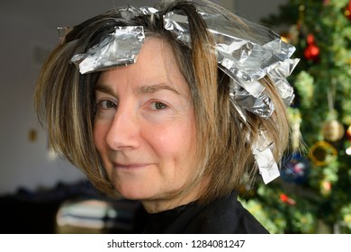 Retired Woman Getting Foil Highlights Hairdressing At Home For Christmas