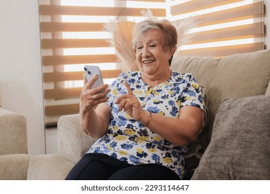 Retired woman spending time on her smartphone - grandmother talking on text messages - Powered by Shutterstock