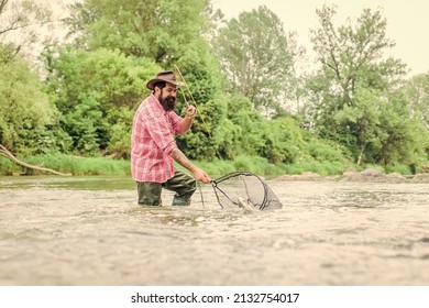 At Retirement. Happy bearded fisher in water. mature man fly fishing. man catching fish. fisherman show fishing technique use rod. summer weekend. Fly fishing. hobby and sport activity