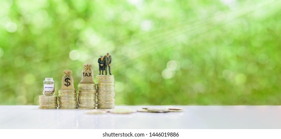 Retirement / pension or income tax and social security benefit concept : Senior american couple, tax bag, US dollar bag, retirement jar on steps of rising coins, depicts preparing money for late life