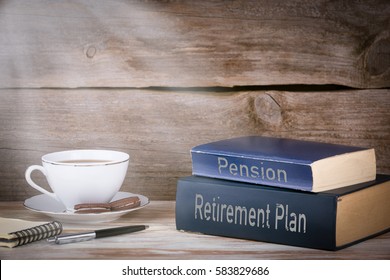 Retirement Plan And Pension. Stack Of Books On Wooden Desk