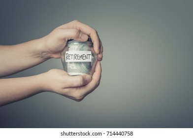 Retirement Savings Concept. Man Hands With Glass Jar Full Of US Dollars. 